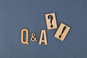 Wooden “Q&A” letters with a question mark and exclamation mark on a blue background