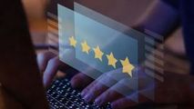 Hand typing on a laptop with a glowing five-star customer rating overlay