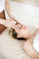 Person receiving a facial massage on a spa bed
