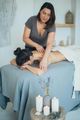 Massage therapist working on a client on a treatment table with candles nearby