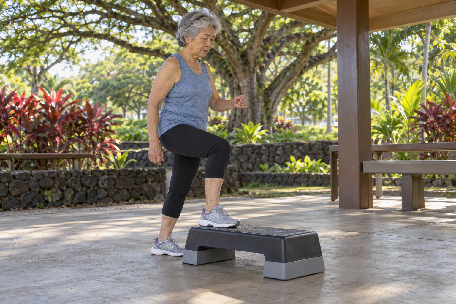 Older woman in Hawaiʻi performing a controlled step-up exercise to build leg strength, balance, and 