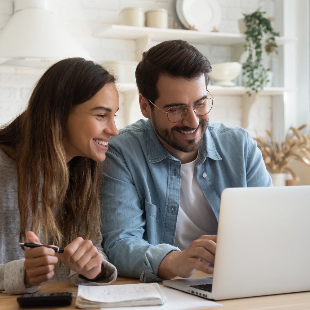 A Happy Couple Browsing on a Laptop