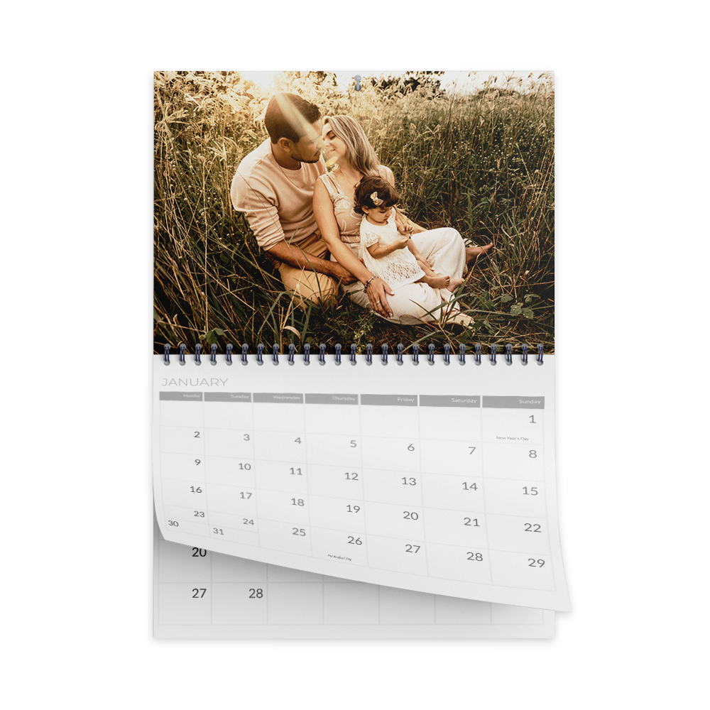 Family photo calendar with a photo of a family sitting in tall grass. The calendar is open to a month.