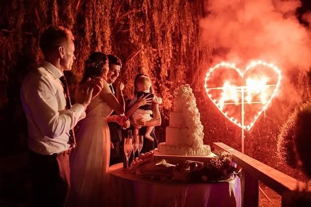 Taglio della torta nuziale con fuochi d'artificio a forma di cuore.