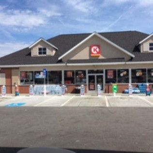 Front view of a Circle K convenience store with parking lot and accessible spaces under a blue sky
