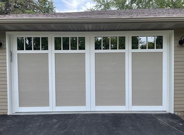 Four-panel garage door with white trim, tan panels, and small rectangular windows above.