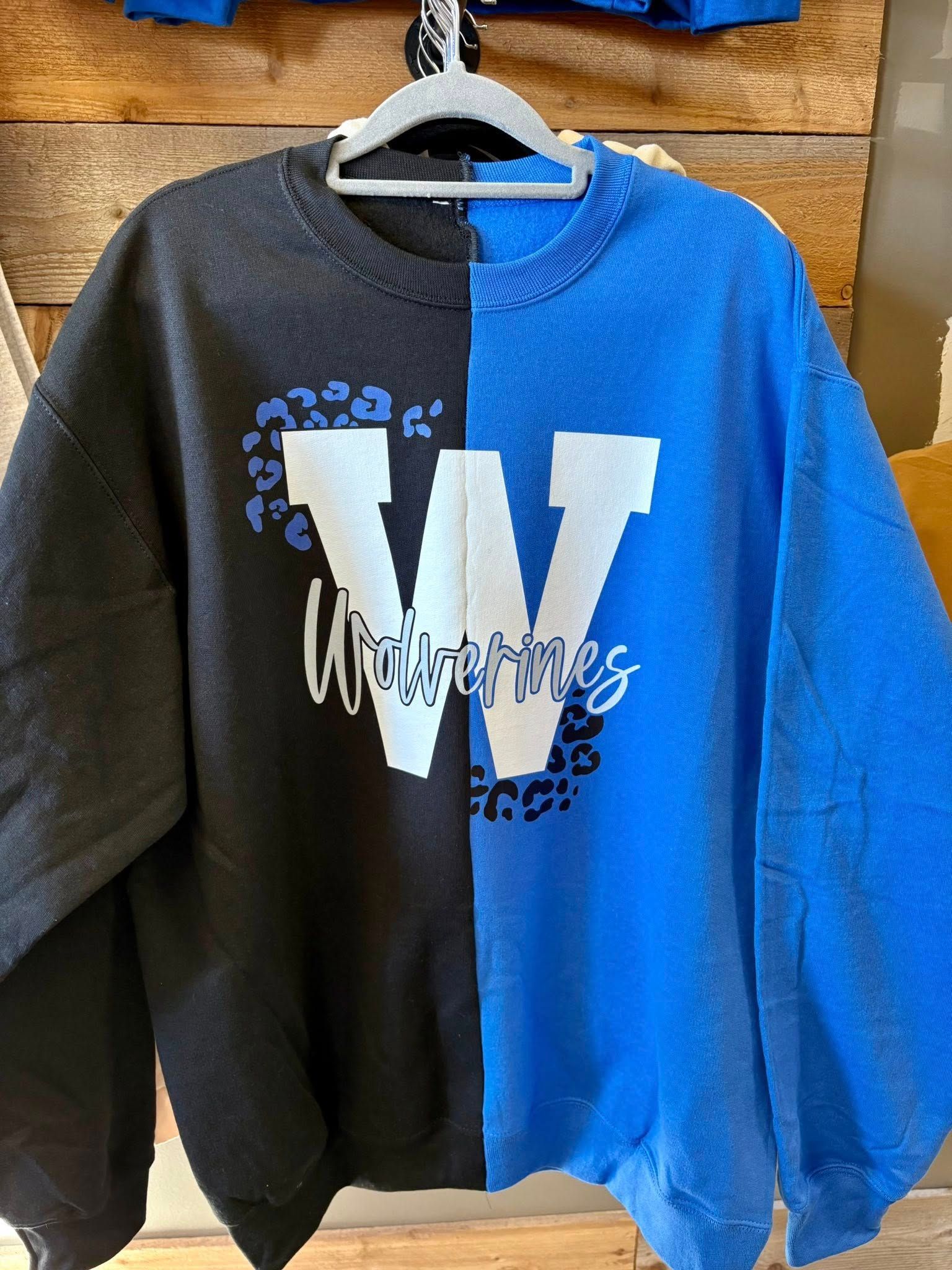 A black and royal blue split-panel sweatshirt featuring a large white