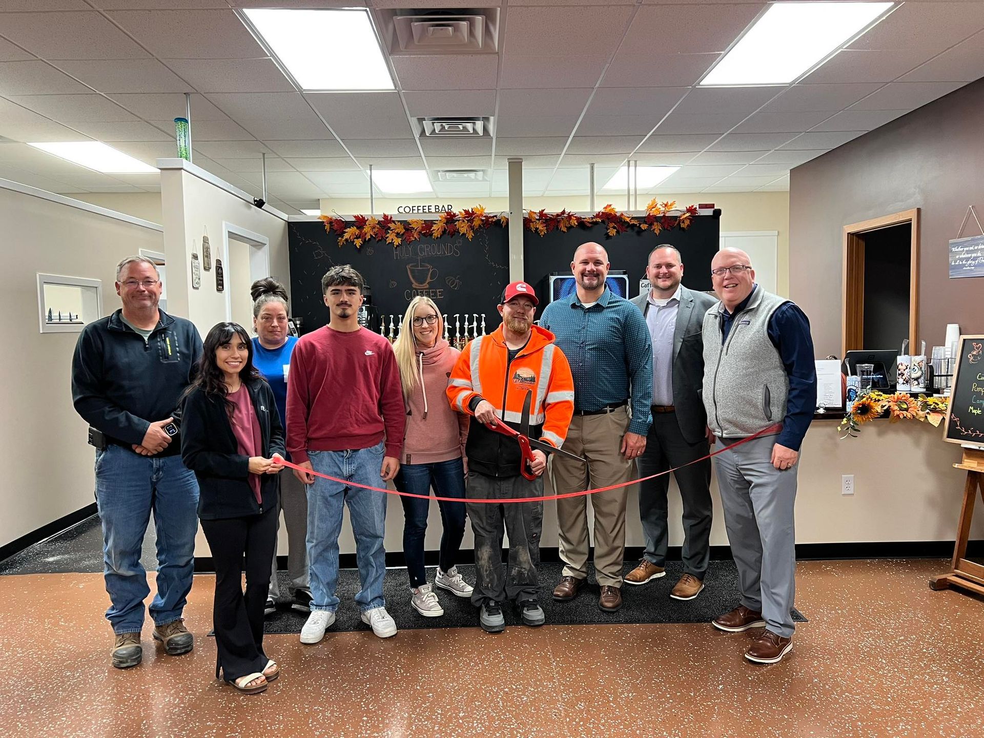 A group of people standing in an office building during a ribbon-cutting ceremony.