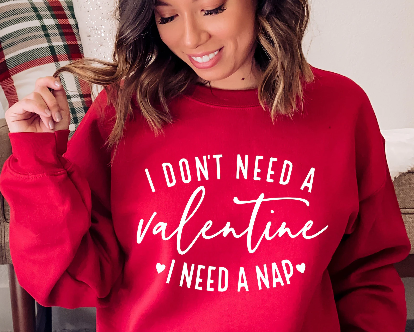 A person wearing a red sweatshirt with white text that reads 