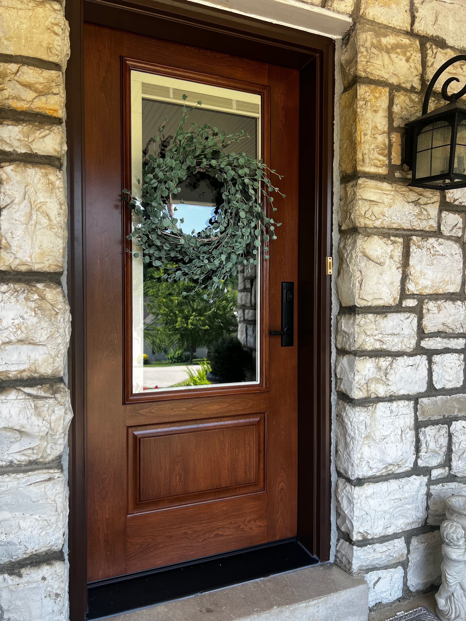 Wooden front door with glass panel in a stone house exterior