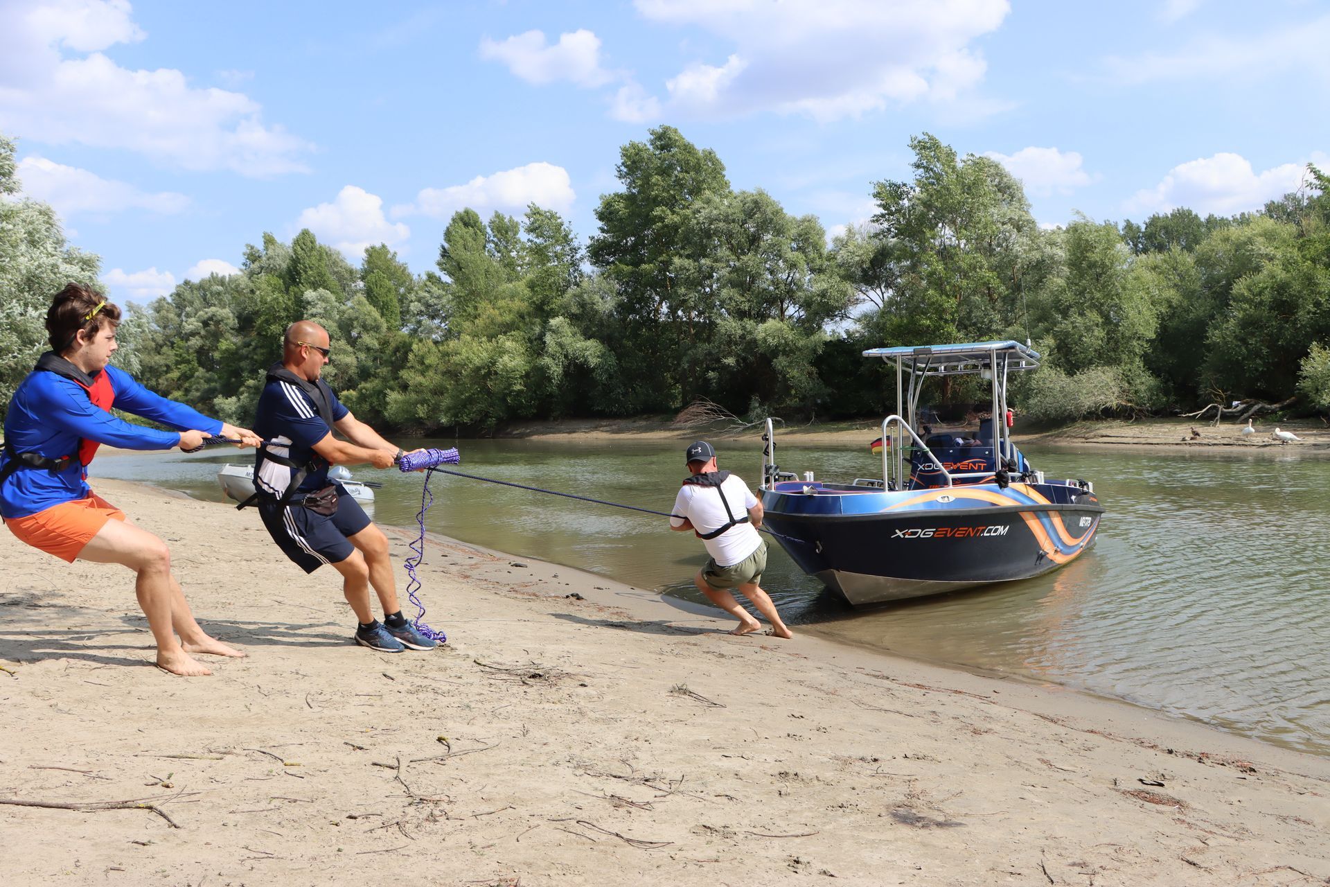 Eine Gruppe von Menschen zieht ein Boot aus dem Wasser