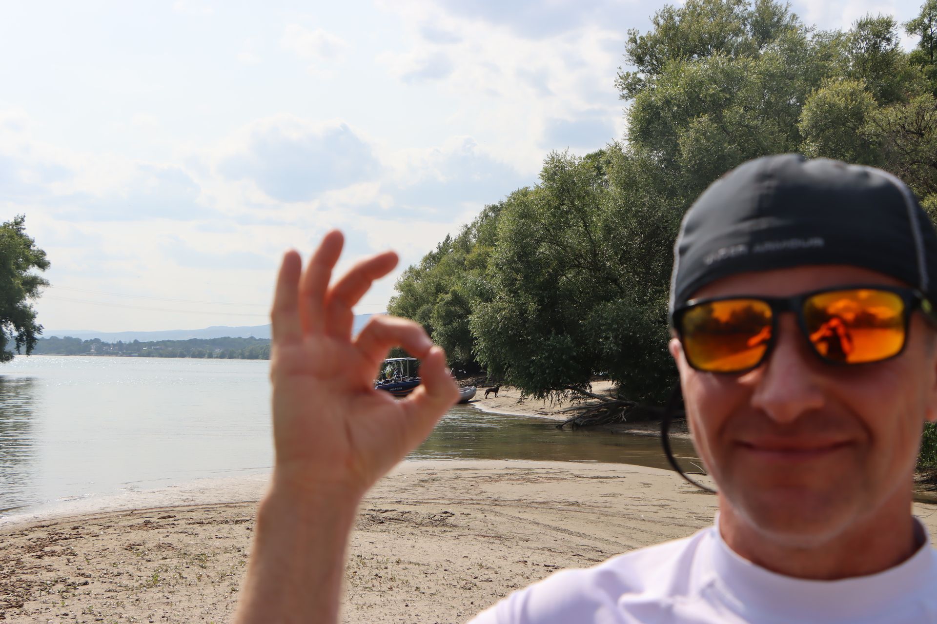 Ein Mann mit Sonnenbrille gibt das OK-Zeichen