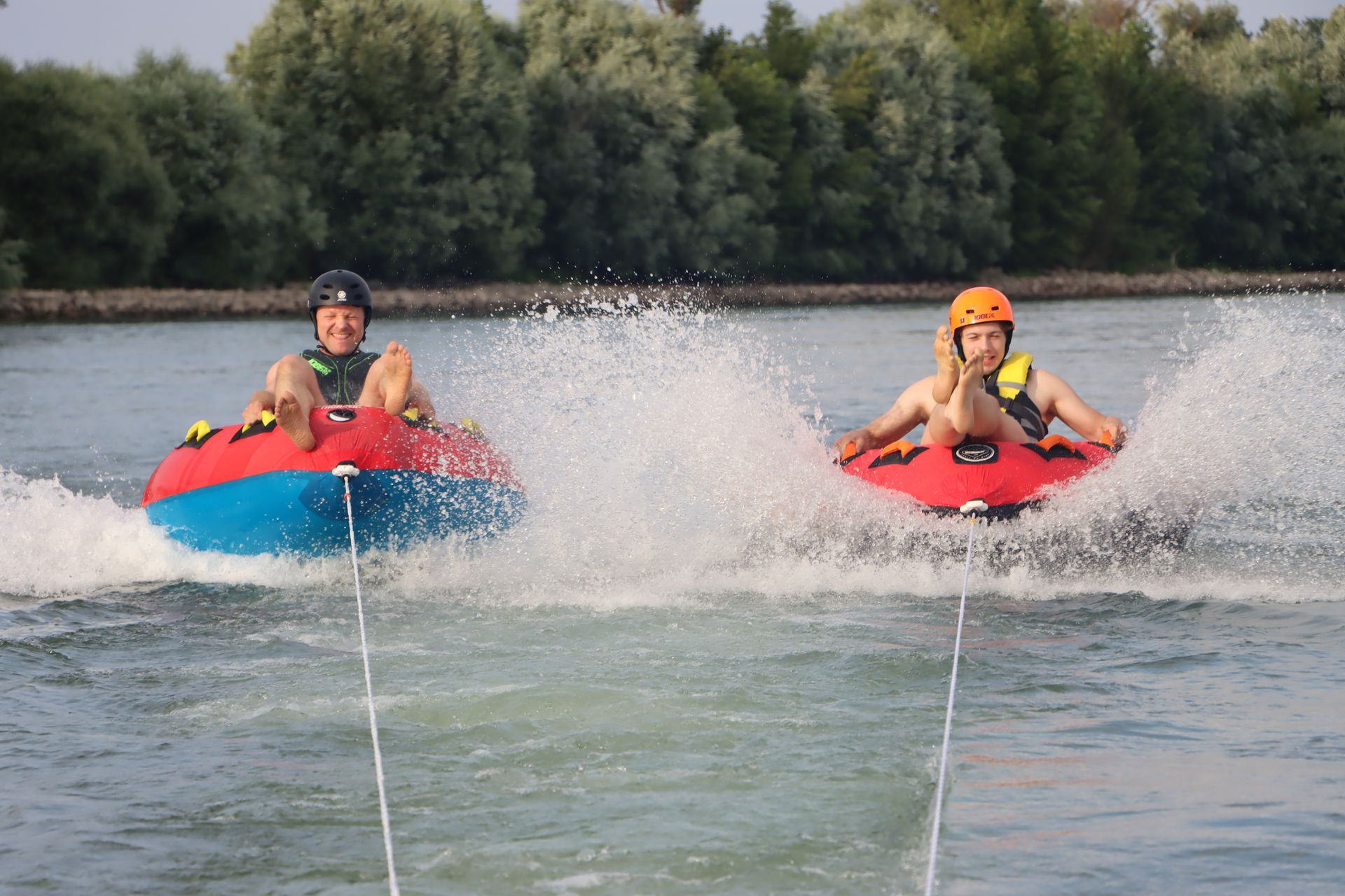 Zwei Personen fahren auf Schläuchen im Wasser