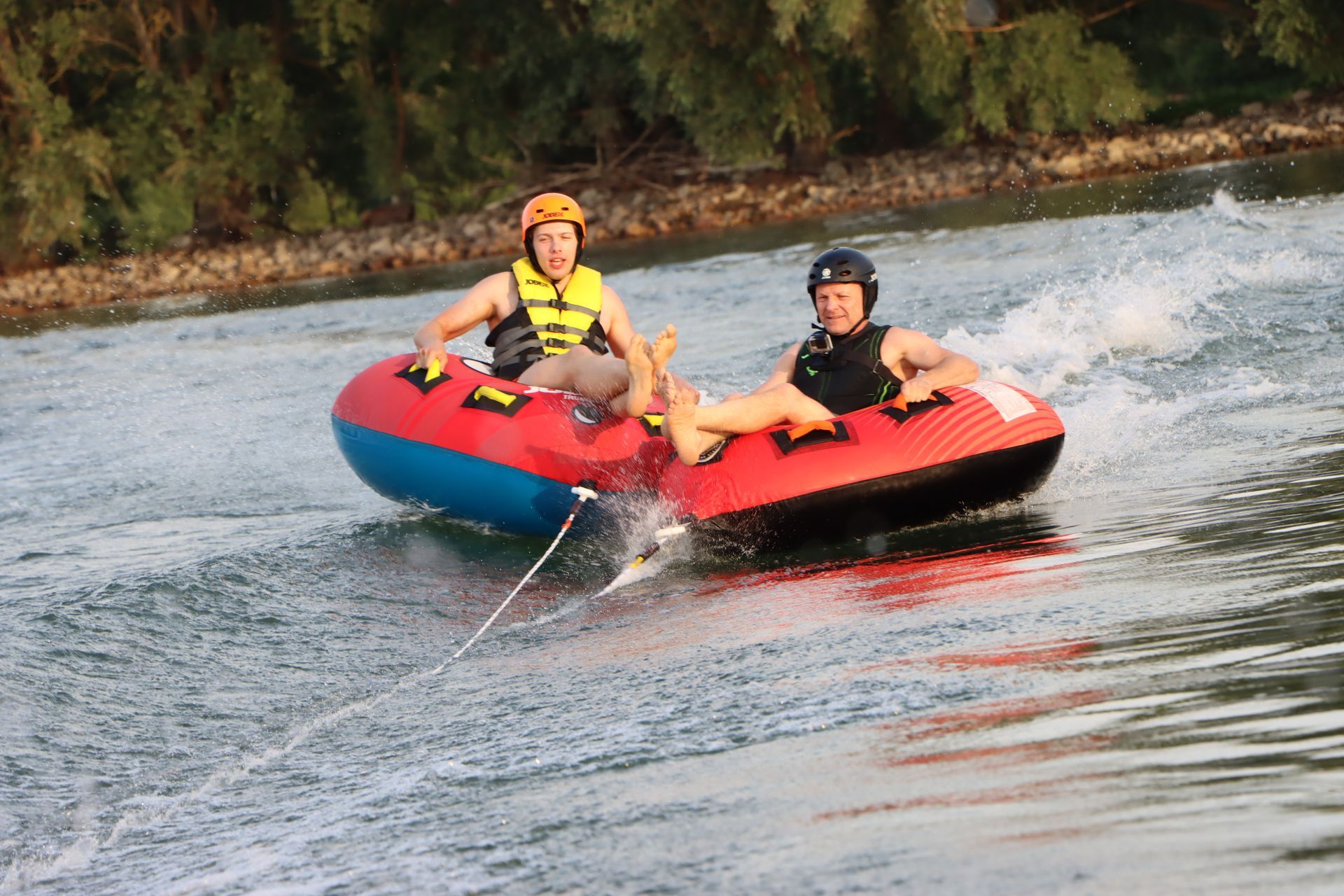Zwei Personen fahren auf einem Schlauch im Wasser