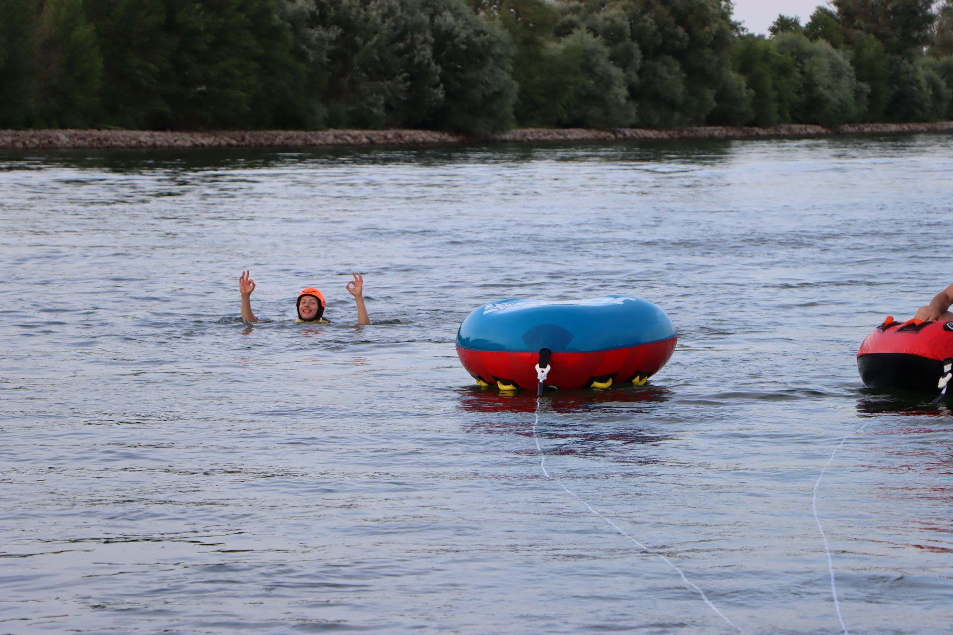Ein Mann schwimmt auf einem Schlauch im Wasser