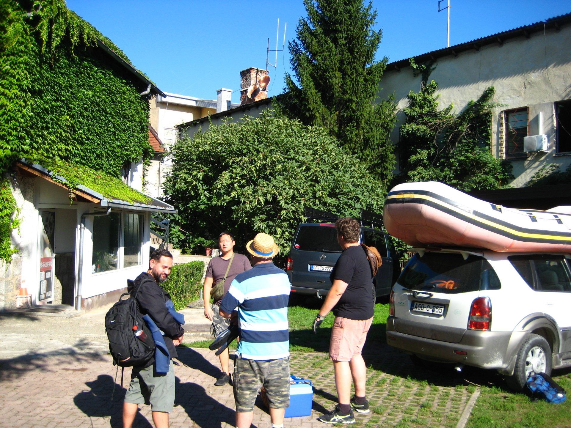 Eine Gruppe von Menschen steht vor einem Auto mit einem Floß darauf