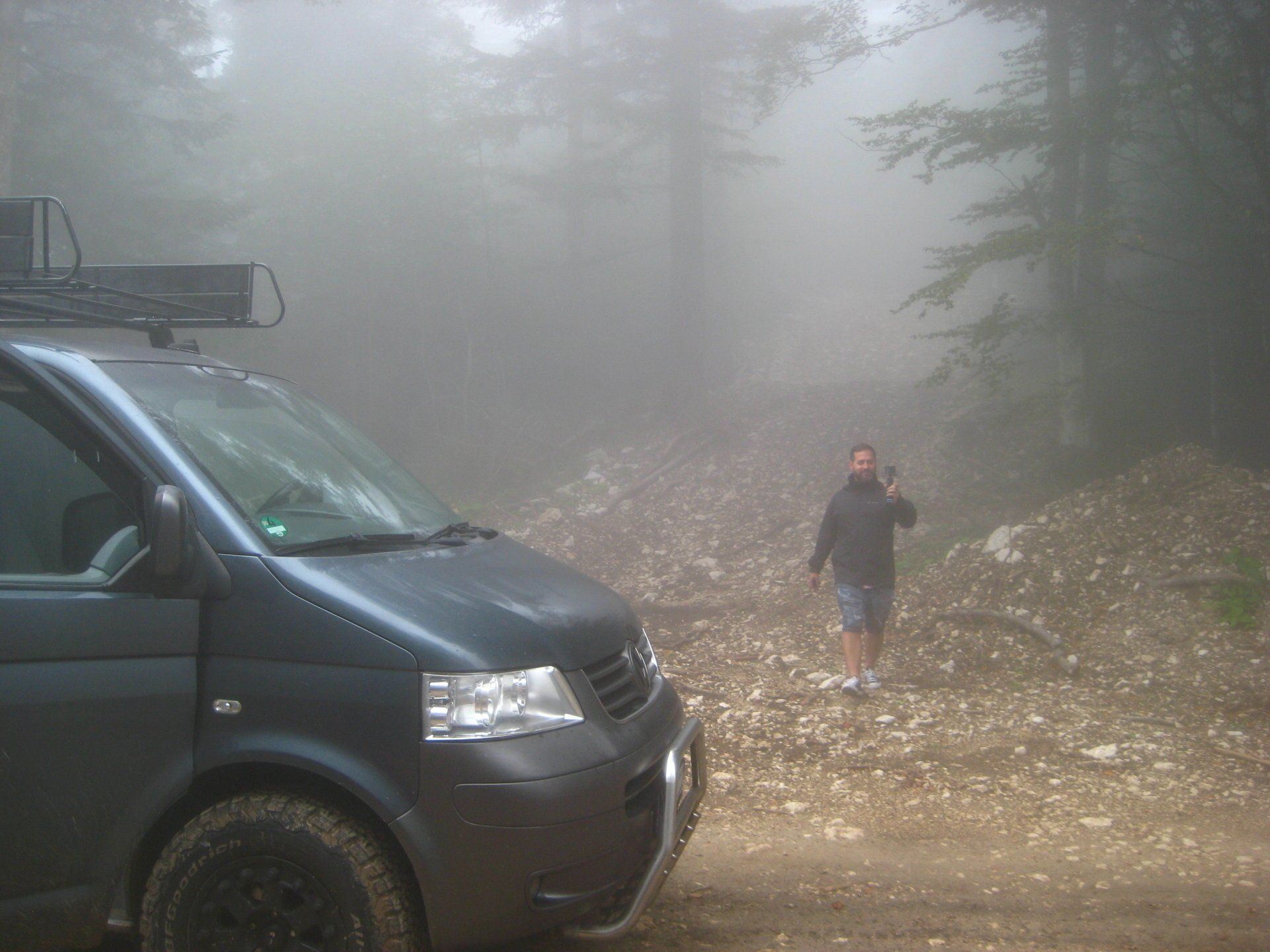 Ein Mann, der im Nebel neben einem Lieferwagen läuft