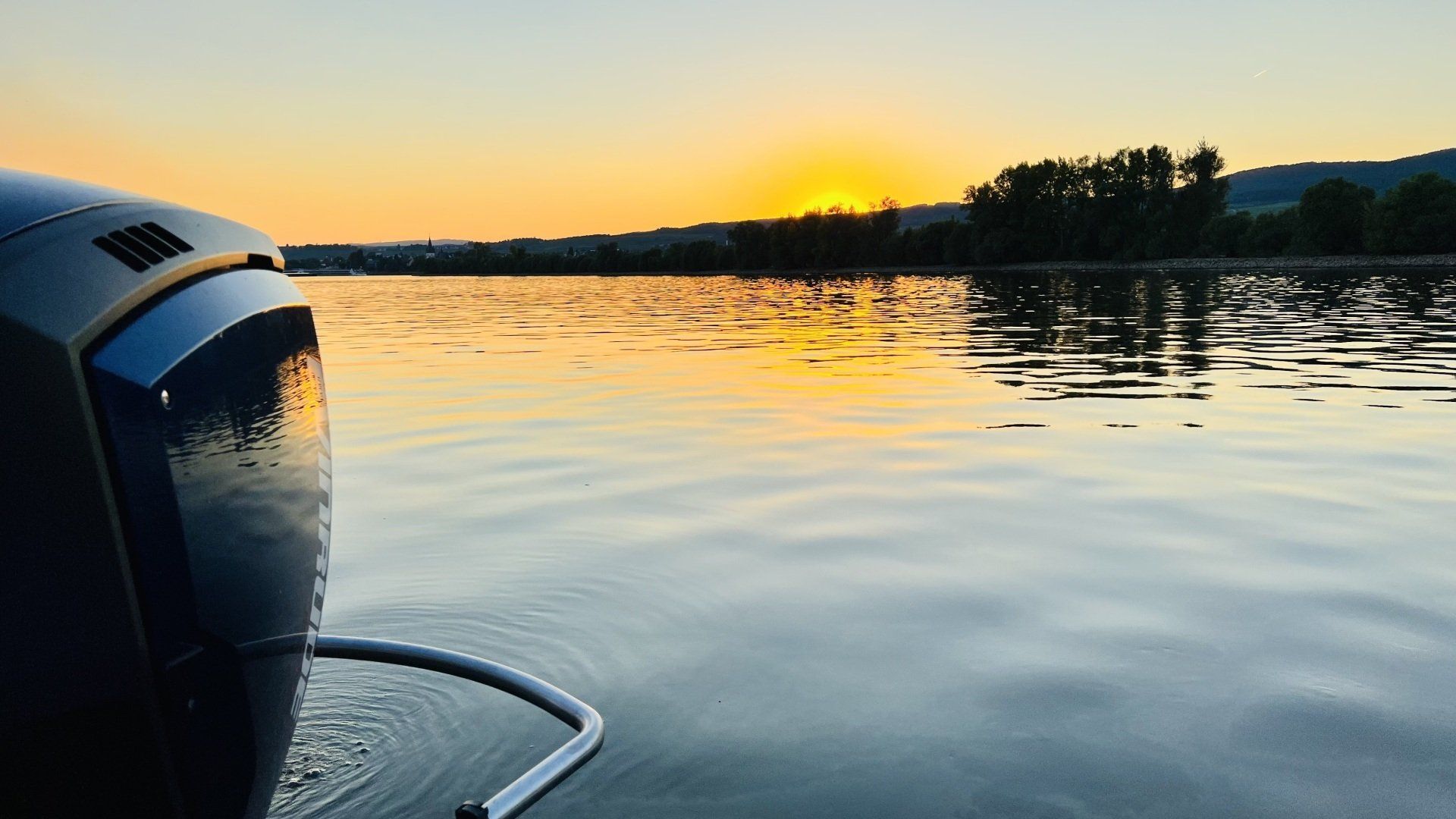 Ein Sonnenuntergang über einem Gewässer mit einem Boot im Vordergrund