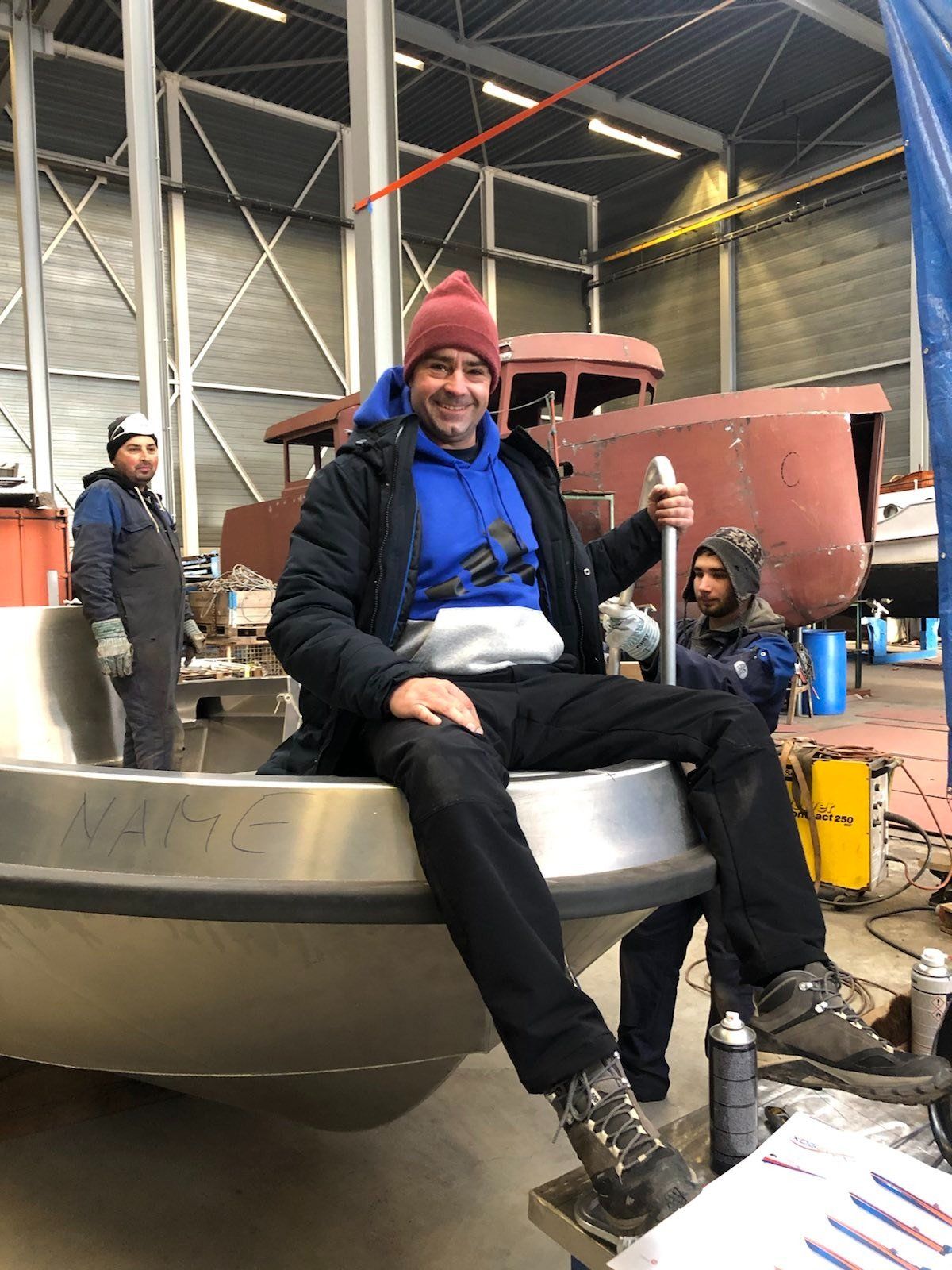 Ein Mann sitzt auf einem Metallgegenstand in einer Fabrik