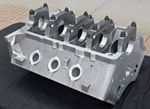 A close up of a cylinder head on a table.