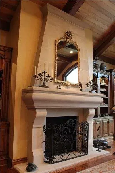 A fireplace with a mantle and candles in a living room.