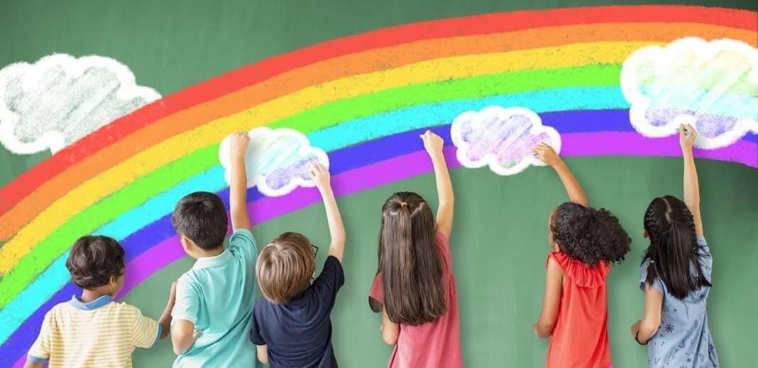 Children painting a bright rainbow mural on a wall with fluffy white clouds