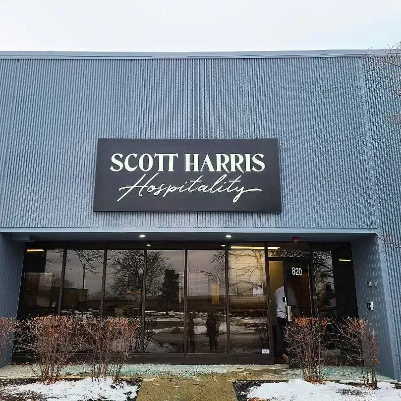 Exterior of Scott Harris Hospitality building with a black sign.