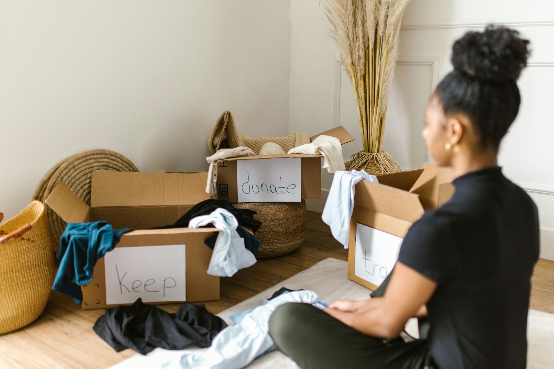 Detroit resident sorting items into boxes and donation pile during decluttering and junk removal