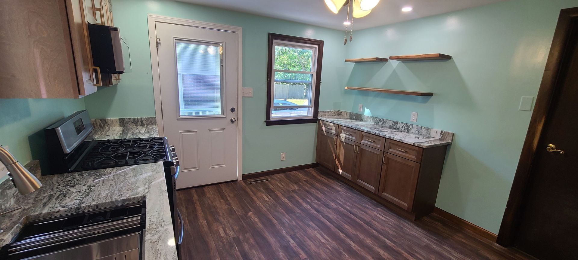 Image of a homeowner's kitchen after a renovation. Light blue walls and new light brown cabinets and cleaned area.