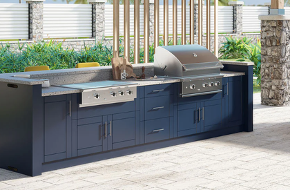 Outdoor kitchen with grill, sink, refrigerator, and dark gray cabinets.