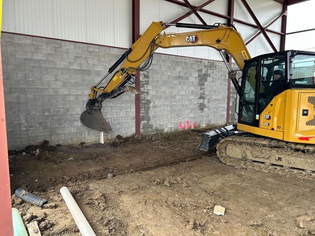 Excavator Performing Ground Work Outside Auto Repair Facility | Auto DR