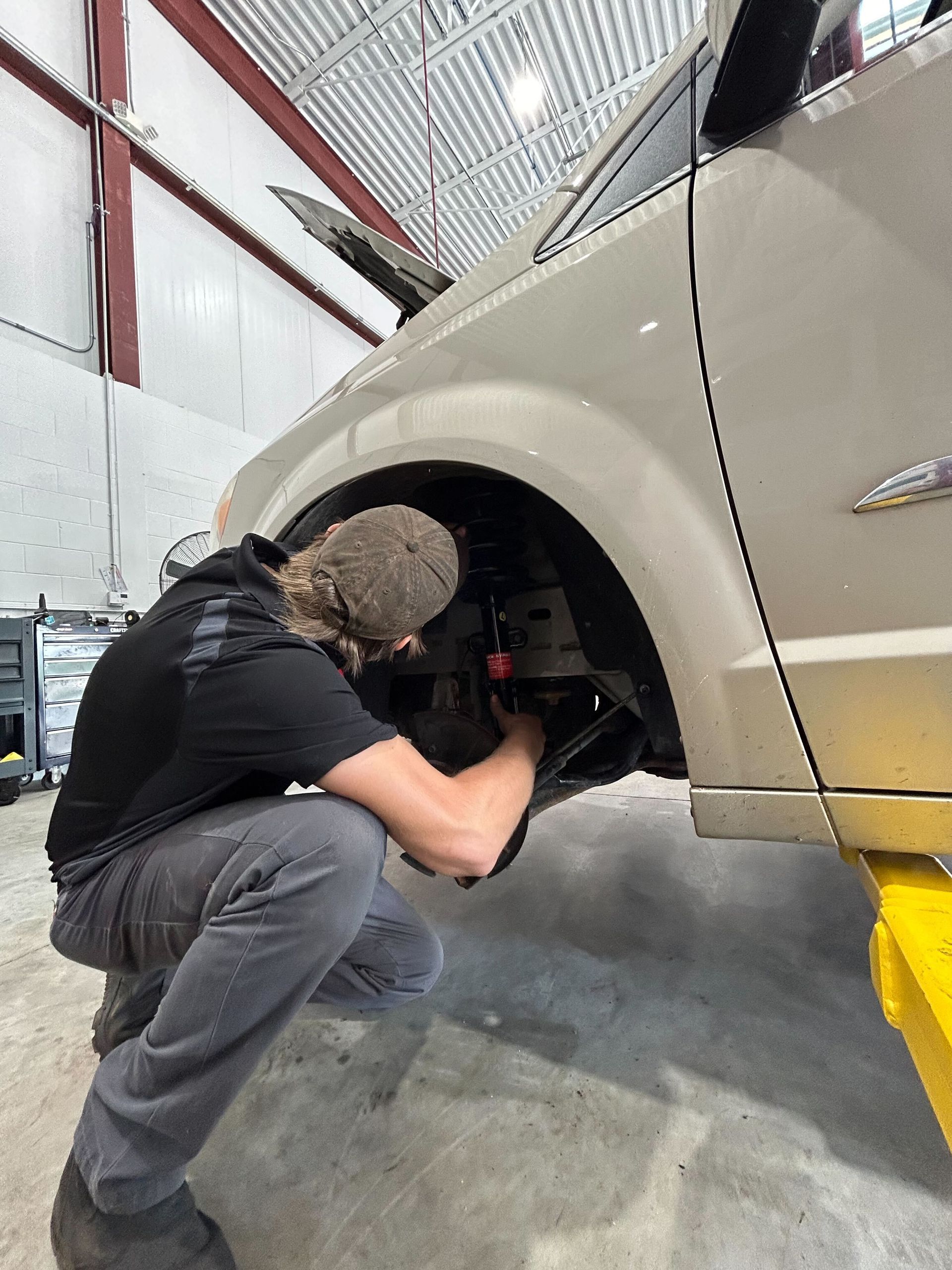 Mechanic Inspecting Suspension Components Near Wheel Well | Auto DR