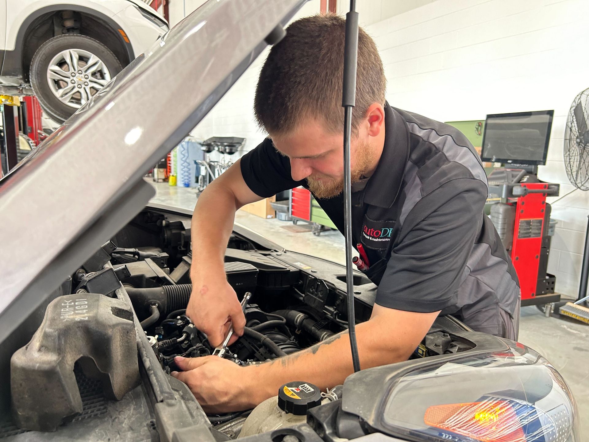 Technician Performing Engine Service Inside Auto Repair Facility | Auto DR
