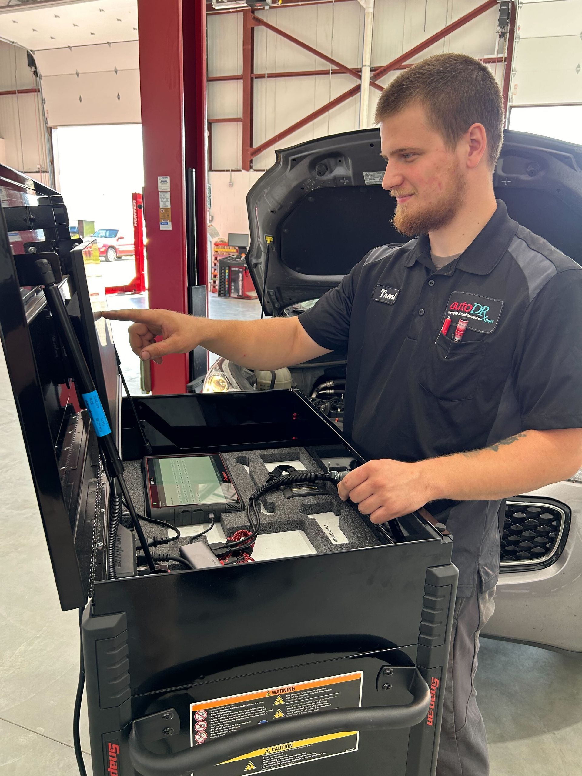 Mechanic Using Diagnostic Equipment In Auto Repair Shop | Auto DR