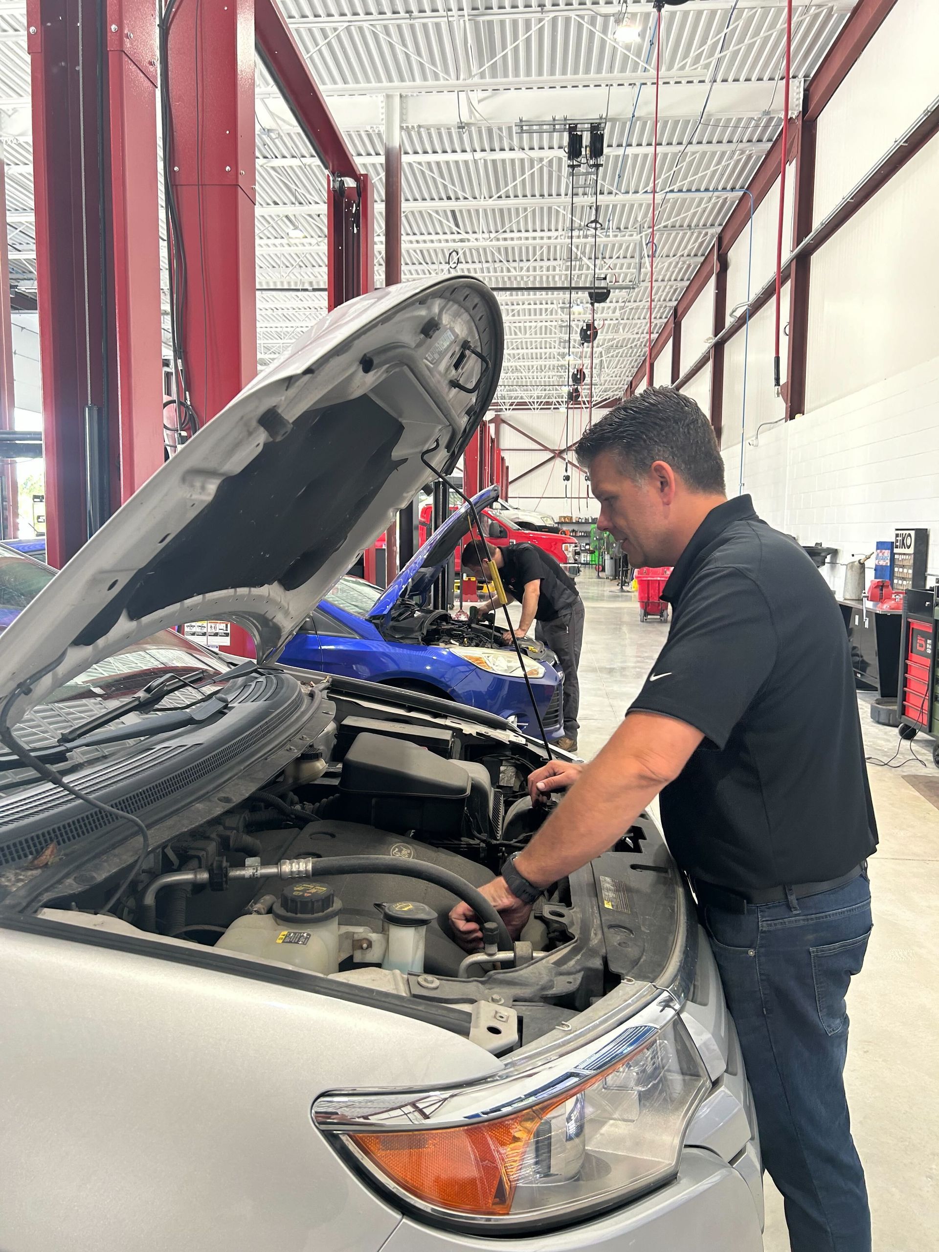 Technician Conducting Engine Diagnostics Inside Service Bay | Auto DR
