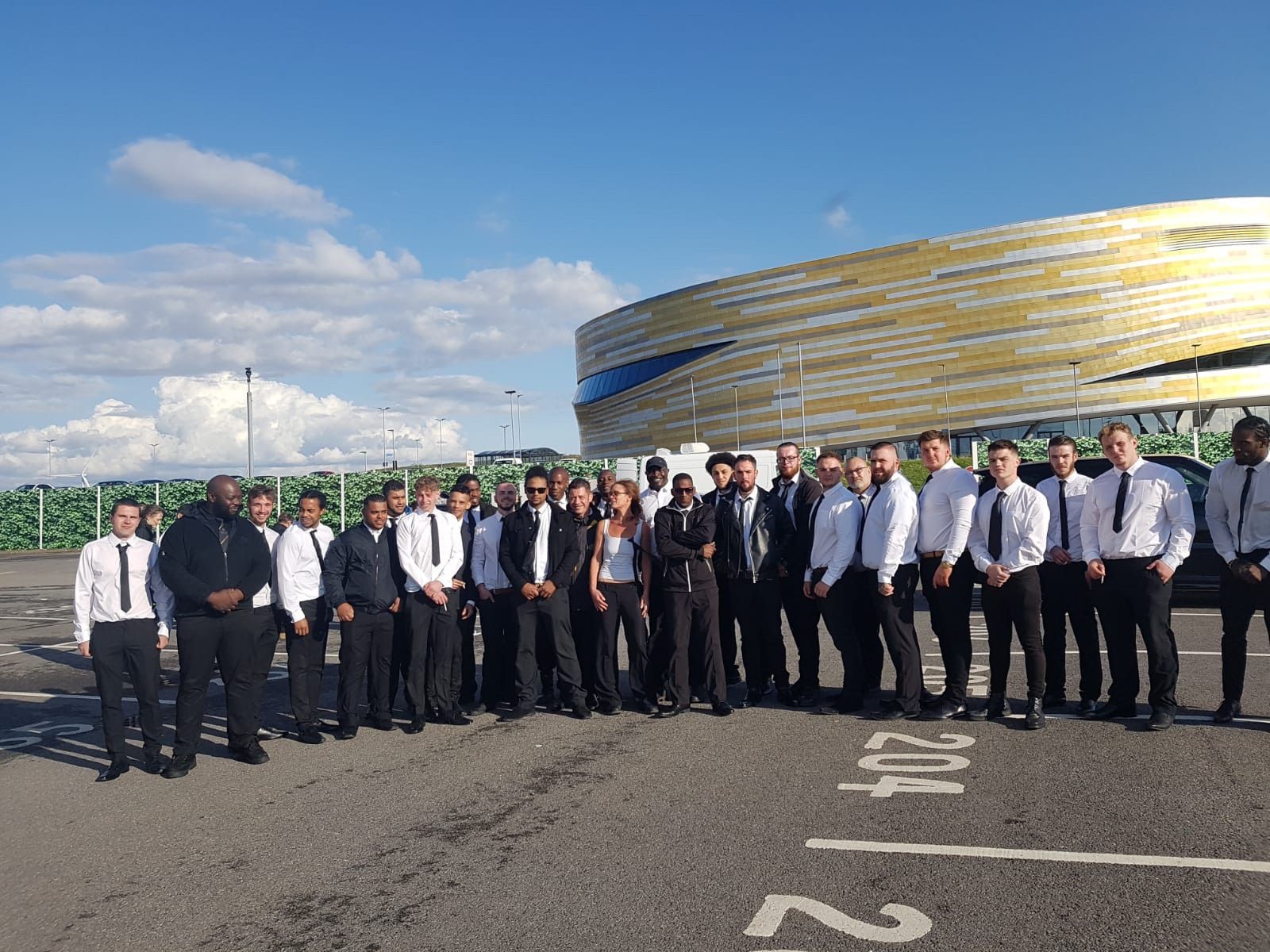A group of people are posing for a picture in front of a large building.