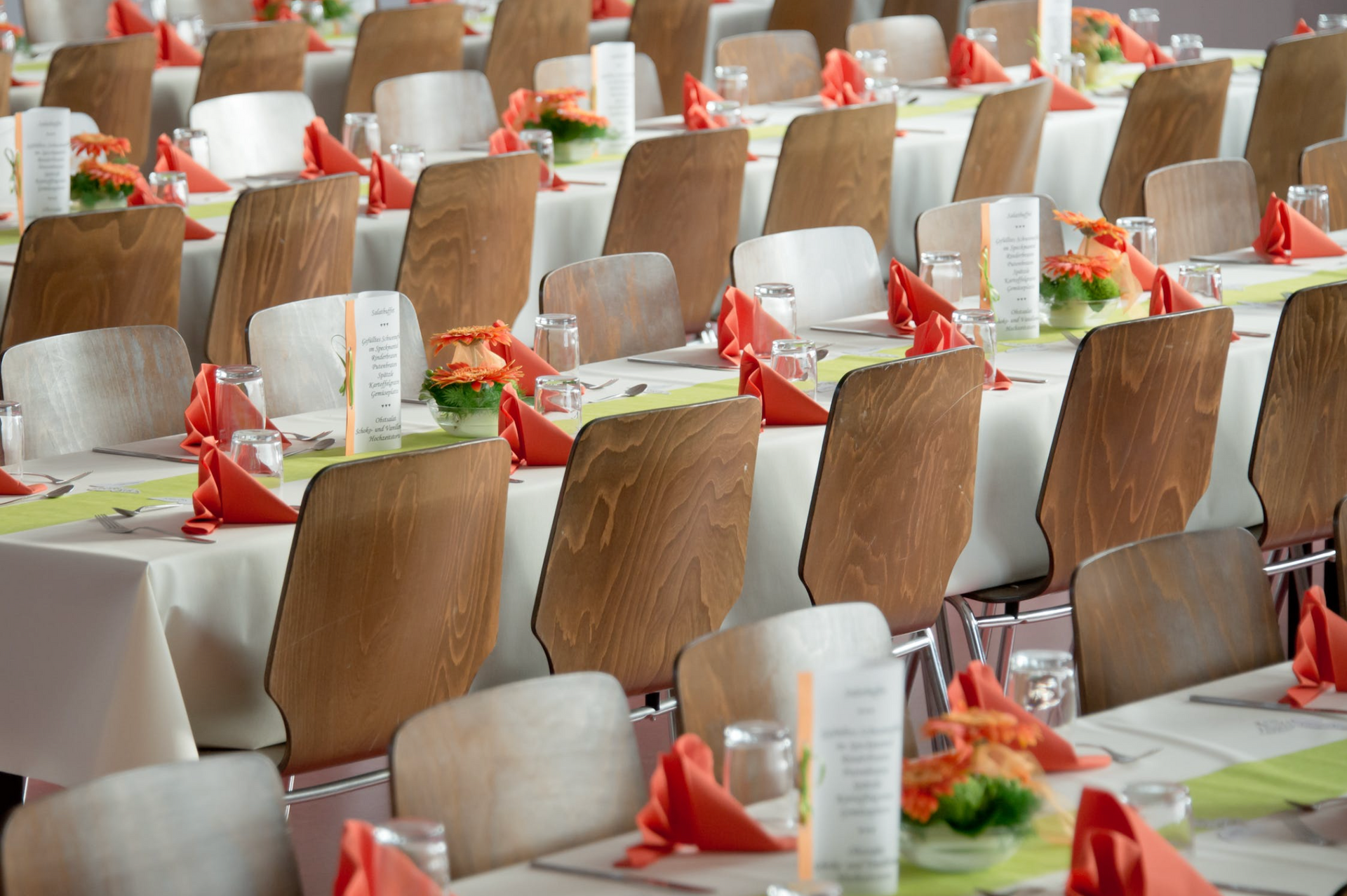a row of tables and chairs are set up for a party .