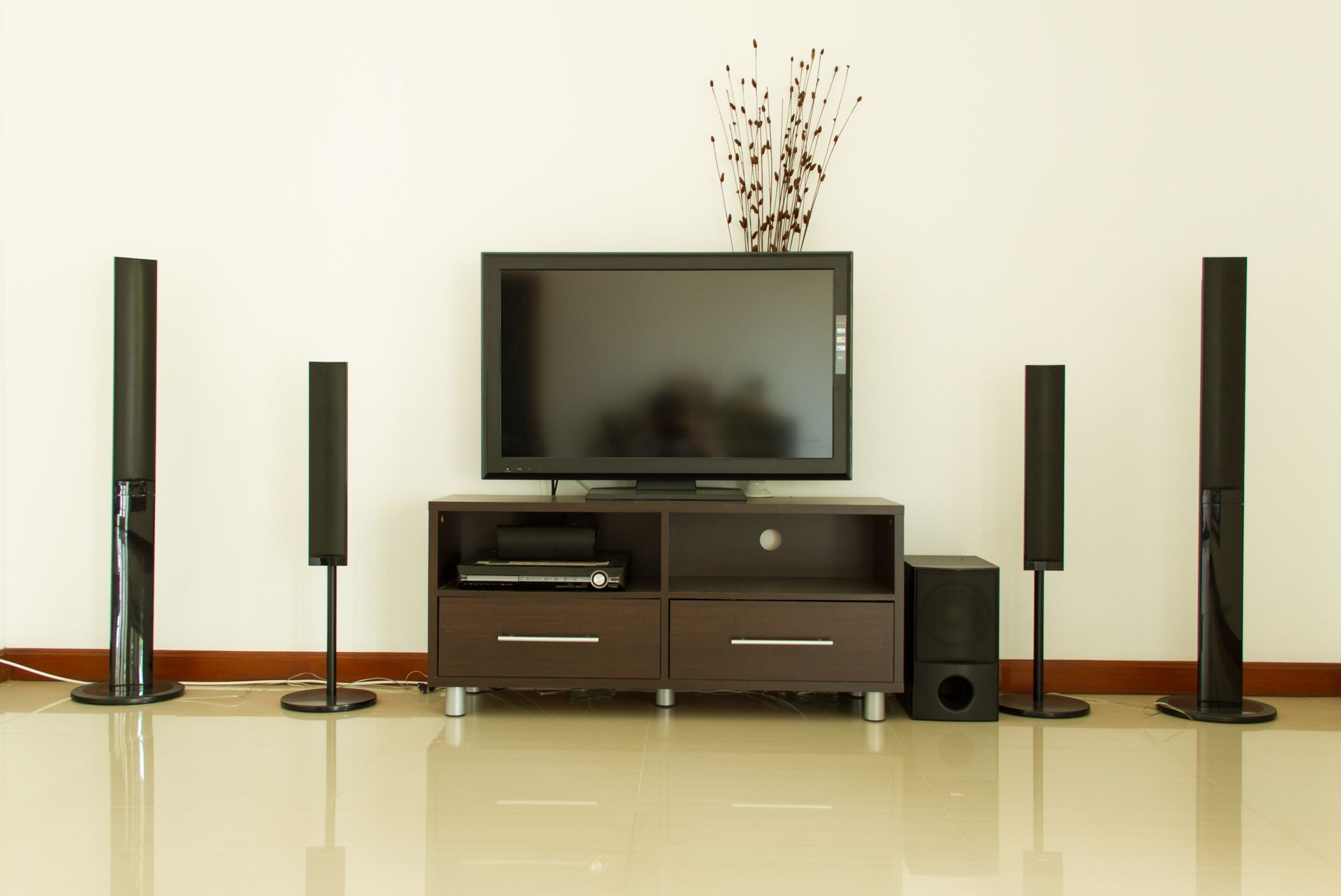 TV entertainment center with surround sound speakers on a white wall.