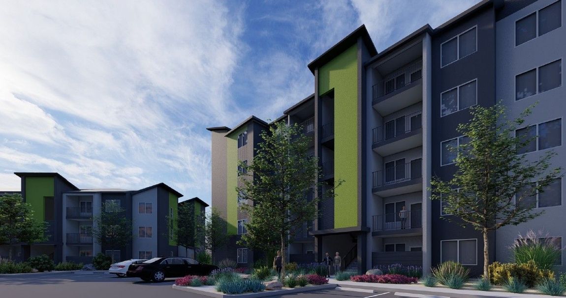 Modern apartment complex with green accents, balconies, and landscaped courtyard under a cloudy sky