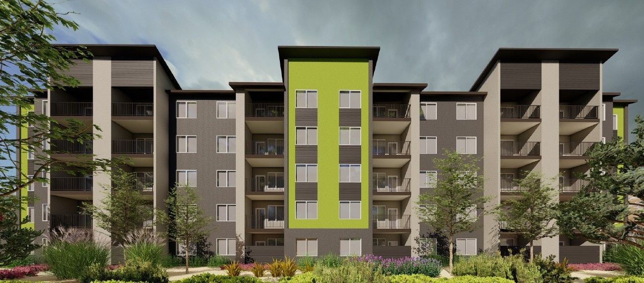 Modern apartment building with a bright green central facade and balconies, surrounded by trees and landscaping