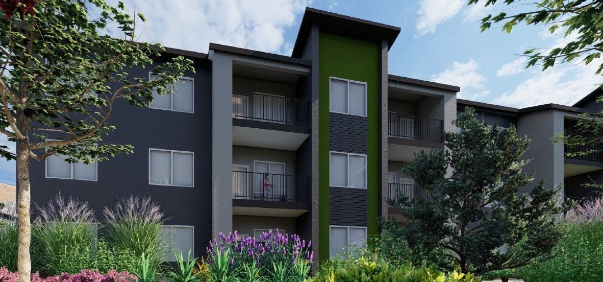 Modern apartment building with balconies, dark gray facade, and lush landscaping
