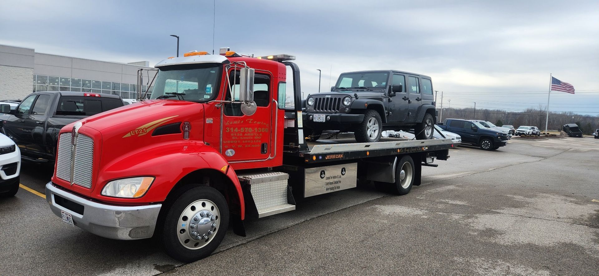 A red tow truck is carrying a jeep on the back of it.