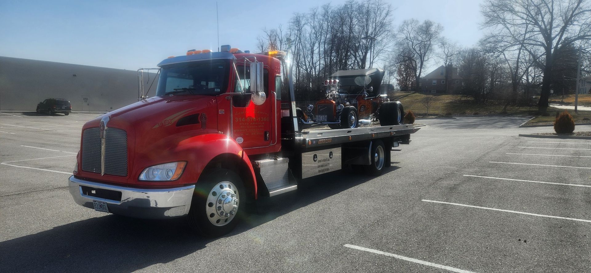 A red tow truck is parked in a parking lot.