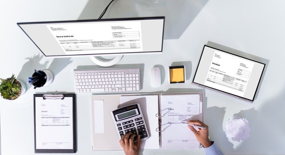 A Person Is Sitting At A Desk Using A Calculator And A Computer — Visionary Accounting In Mudgee, NSW