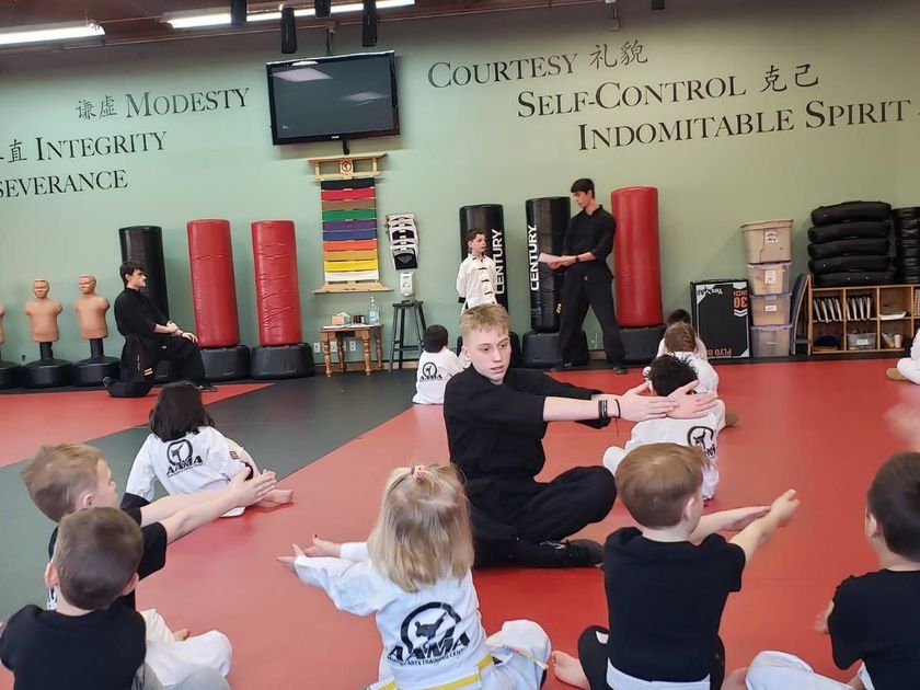 Mixed-age martial arts class practicing forms