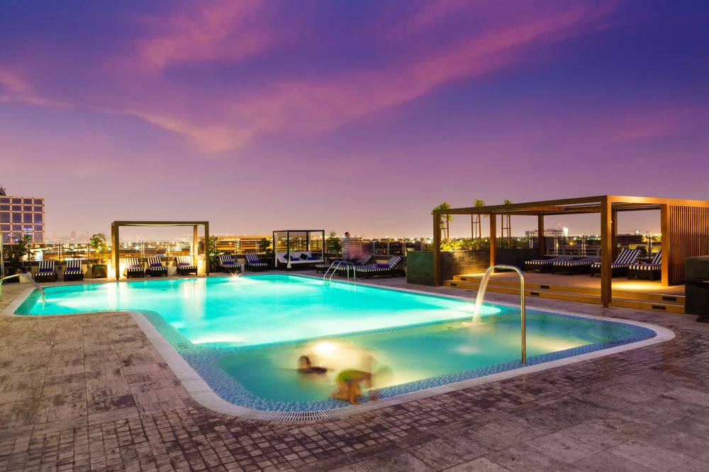 A Large Swimming Pool is Lit Up at Night —  Focus On Water In Cannonvale, QLD