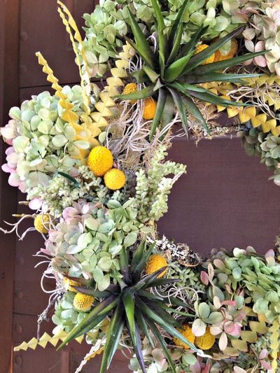 A close up of a wreath with flowers and plants