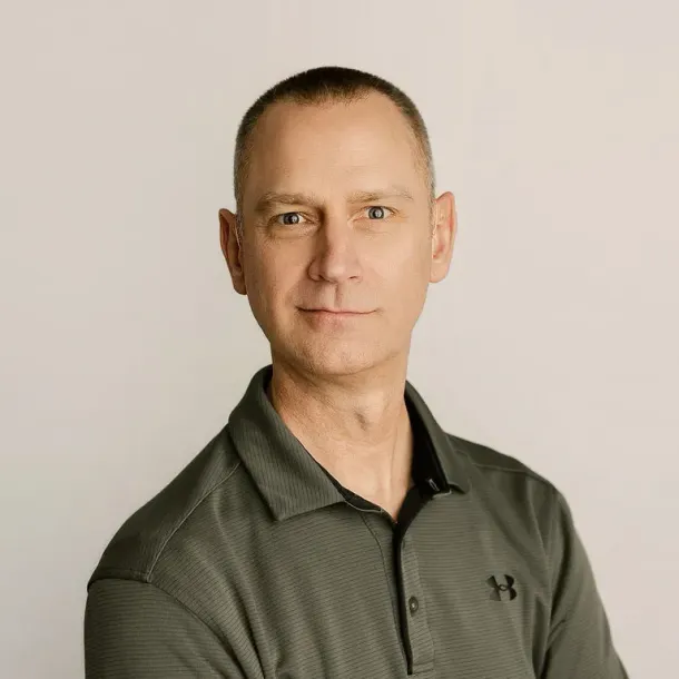 Portrait of a man in a dark green polo shirt against a light background