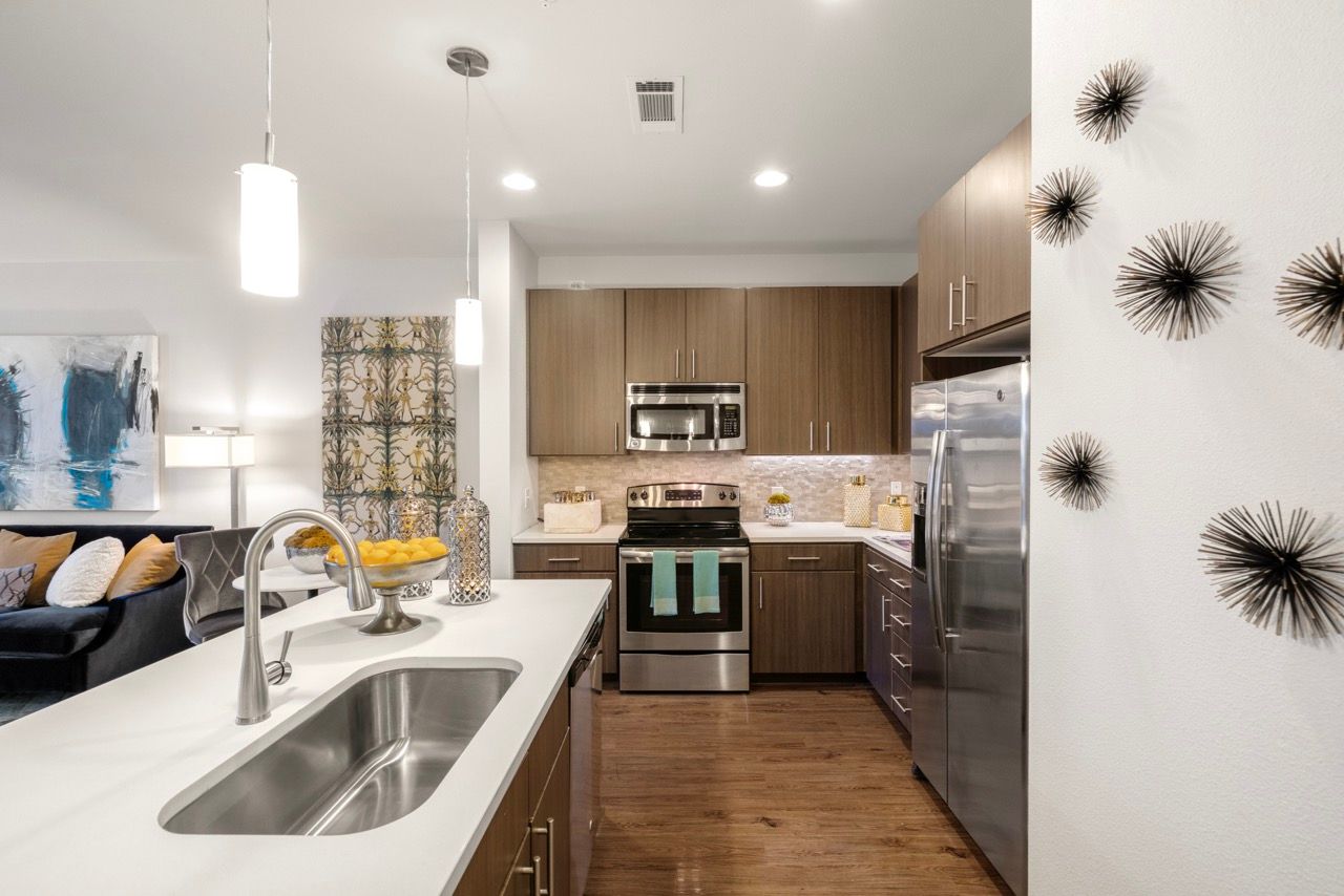 Modern kitchen with an island, stainless-steel appliances, and wooden cabinets.
