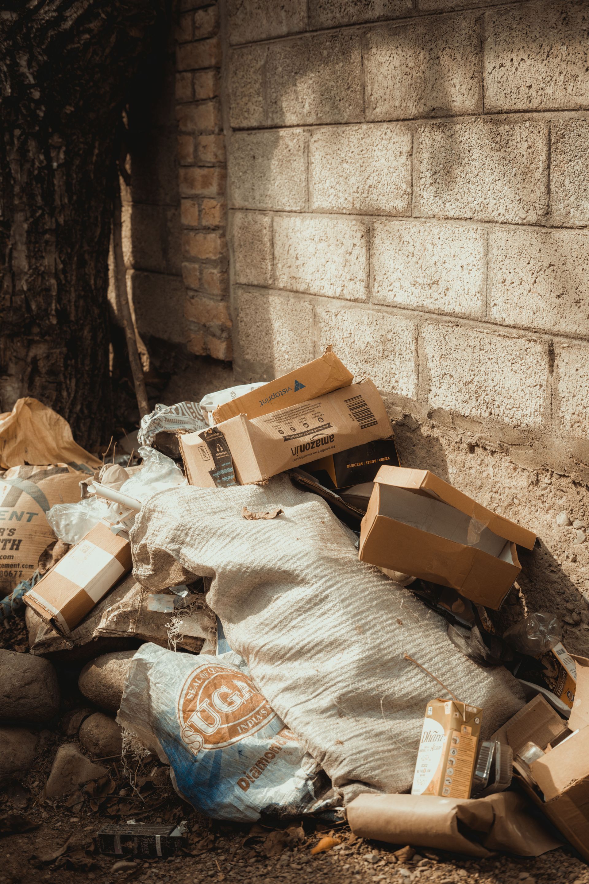 Construction worker diligently collecting waste materials at a job site and placing them into a sturdy bag for disposal.